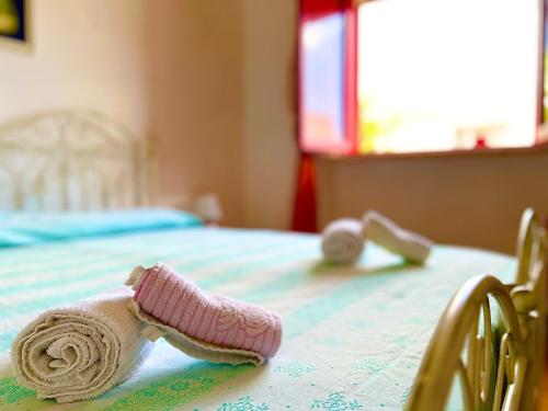 a pair of baby shoes and towels on a bed at Summer Holiday - Torre Vado in Torre Vado