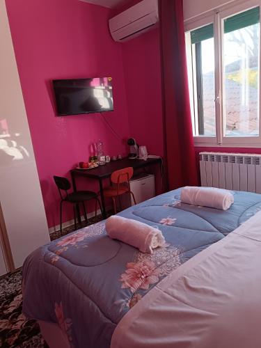 a bedroom with pink walls and a table and a bed at Locazione turistica 2 in Tessera