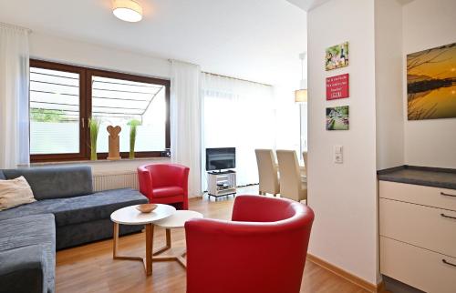 a living room with a couch and a table and chairs at Ferienwohnungen by Weingut Hommes in Ernst Mosel in Ernst