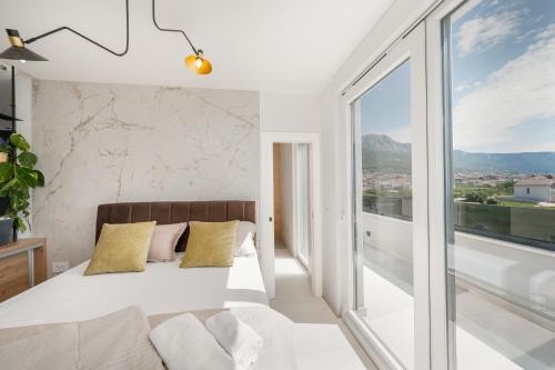 a bedroom with a bed and a large window at Penthouse FRANITA 50 meters from the beach in Kaštela