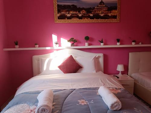 a bedroom with a white bed with pink walls at Locazione turistica 2 in Tessera