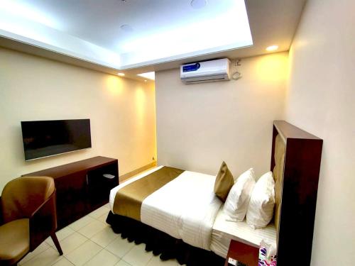 a hotel room with a bed and a tv at Tourister Bd Ltd in Dhaka