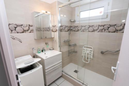 une salle de bain avec une douche, des toilettes et un lavabo dans l'établissement T2 Pierres de Jade avec piscine, à Saint-Cyprien