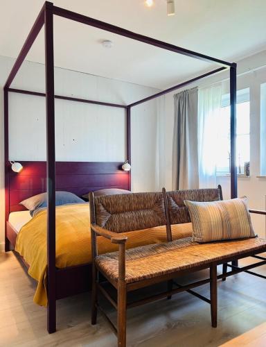 a bedroom with a canopy bed and a bench at Ferienhaus Landleven in Saal