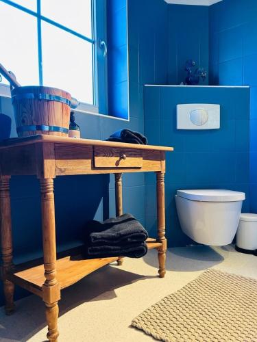 a blue bathroom with a wooden table and a toilet at Ferienhaus Landleven in Saal