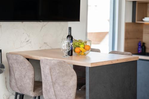 a table with a bottle of wine and oranges on it at Penthouse FRANITA 50 meters from the beach in Kaštela