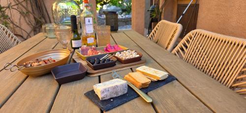 un tavolo di legno con cibo e bottiglie di vino e formaggio di La Fuente de Vida a Turre