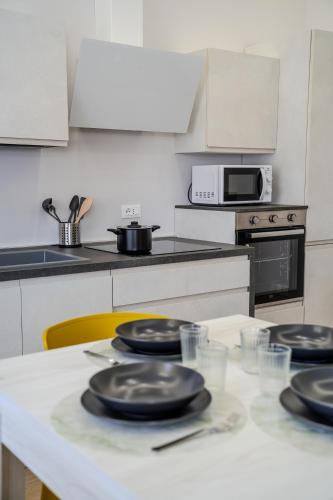 a kitchen with a table with black plates on it at Luxury Acclavio Apartments in Taranto