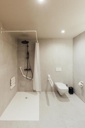 a white bathroom with a toilet and a shower at Getaway Studios Liège in Liège