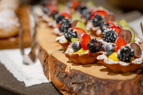 a row of small appetizers on a wooden cutting board at Palace Hotel Wellness & Beauty in Bormio