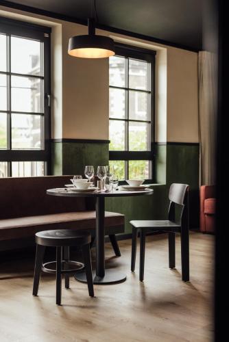 a dining room with a table and chairs and windows at Getaway Studios Liège in Liège