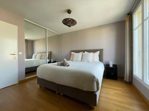 Un dormitorio con una cama grande y un espejo grande. en Luxury Villa&6 pers&Parking free, en Magny-le-Hongre