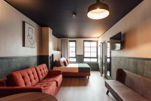 a hotel room with a couch and a bed at Getaway Studios Liège in Liège
