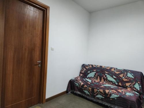 a bedroom with a bed next to a wooden door at Five Leo’s villa in Gadok 1