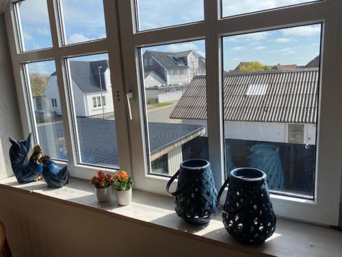a window with three vases sitting on a window sill at Dejlig gårdhave 5 soveværelser in Harboør