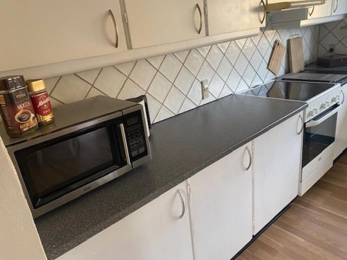 a kitchen with a microwave on a counter top at Dejlig gårdhave 5 soveværelser in Harboør