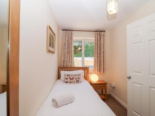 un dormitorio con una cama y una ventana en Moorside, en Horrabridge