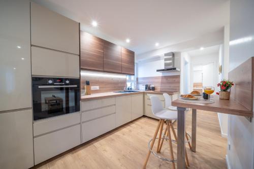 a kitchen with white cabinets and a table with chairs at Le Refuge Pétillant - Terrasse et Jardin in Haguenau