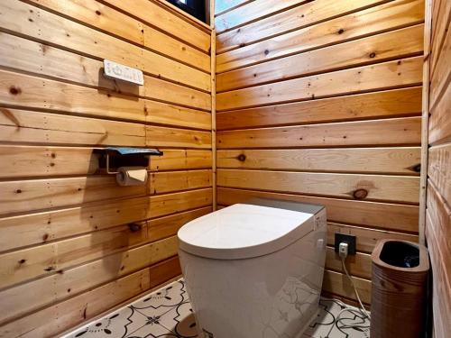 a bathroom with a toilet in a wooden wall at turpan Ah Fanti Village in Turfan