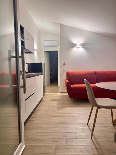 a living room with a red couch and a table at Galaxy Rooms Tropea in Drapia