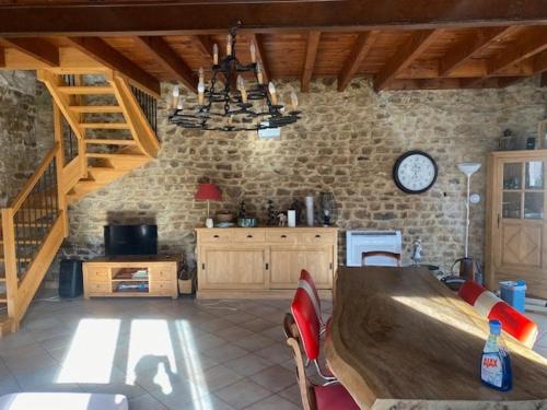 a kitchen with a table and a clock on the wall at gite meymac in Meymac