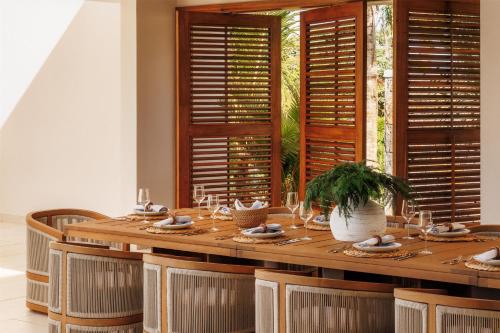 a dining room with a wooden table and chairs at One&Only Le Saint Géran, Mauritius in Belle Mare