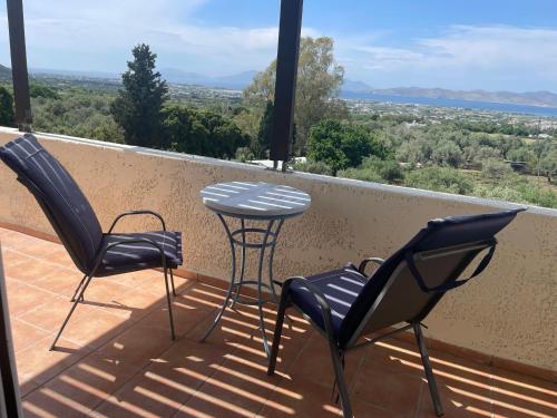 two chairs and a table on a balcony with a view at Carpe Diem in Zipárion