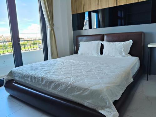 a bedroom with a large bed with a large window at Kellky Homestay Phú Quốc in Phu Quoc