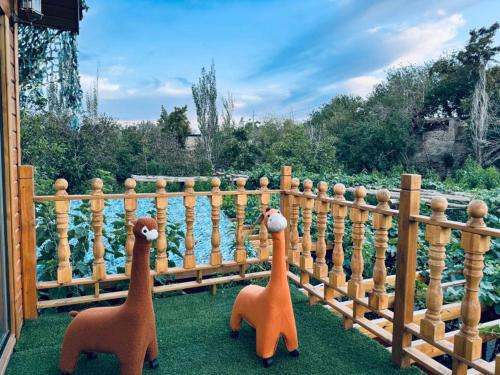 two stuffed animals standing next to a wooden fence at turpan Ah Fanti Village in Turfan