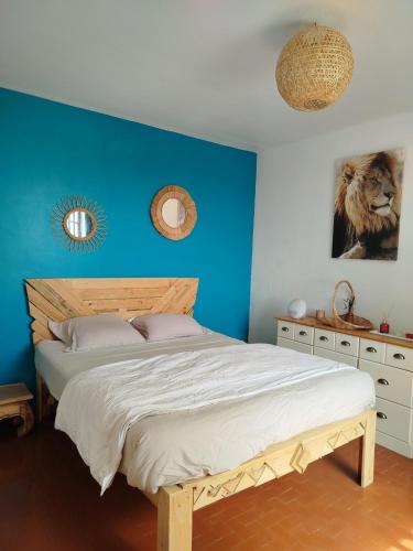 une chambre avec un lit avec un mur bleu dans l'établissement Havre de paix à la campagne - Pet Friendly, à Cruis