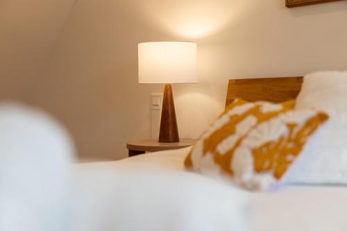 a bedroom with a bed and a lamp on a table at Le Refuge Pétillant - Terrasse et Jardin in Haguenau