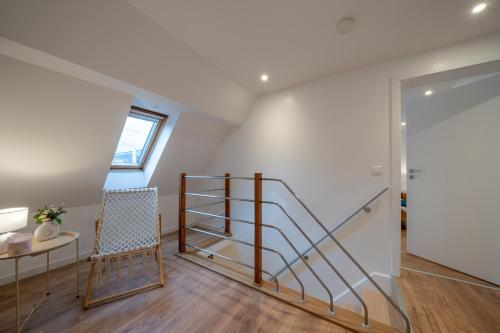 a room with a staircase and a table and a chair at Le Refuge Pétillant - Terrasse et Jardin in Haguenau