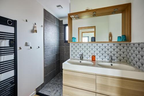 une salle de bain avec deux lavabos et un miroir dans l'établissement La Côte des îles - à 600m de la plage, à Les Moitiers-dʼAllonne
