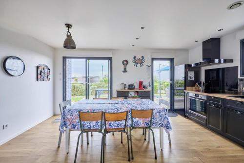 une cuisine avec une table et quatre chaises dans l'établissement La Côte des îles - à 600m de la plage, à Les Moitiers-dʼAllonne