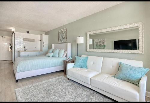 sala de estar con sofá blanco y cama en BeachAHolic paradise, en Myrtle Beach