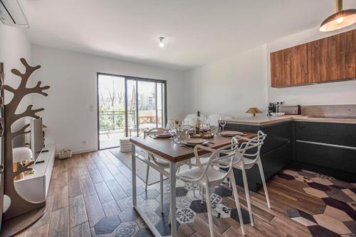 une cuisine avec une table et des chaises dans une pièce dans l'établissement Appartement T3 de charme avec Terrasse - Hauteurs Bastia, à Bastia