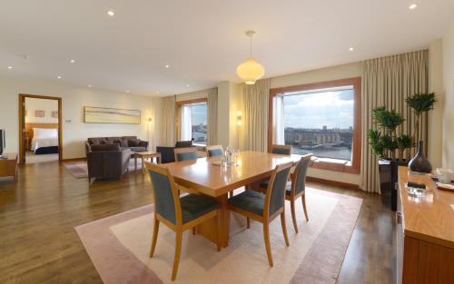 a dining room and living room with a table and chairs at Canary Riverside Plaza Hotel in London