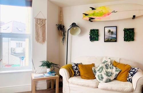 a living room with a couch and a window at Modern, spacious surf retreat in a prime location in Newquay