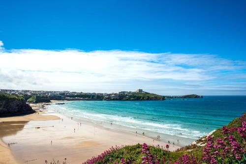 a view of a beach with people in the water at Modern, spacious surf retreat in a prime location in Newquay