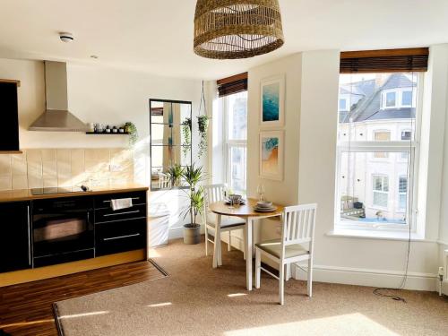 a kitchen with a table and a dining room at Modern, spacious surf retreat in a prime location in Newquay