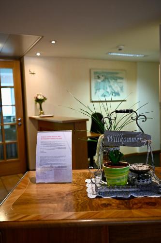 a table with a sign and a potted plant on it at Hotel Du Lac in Interlaken