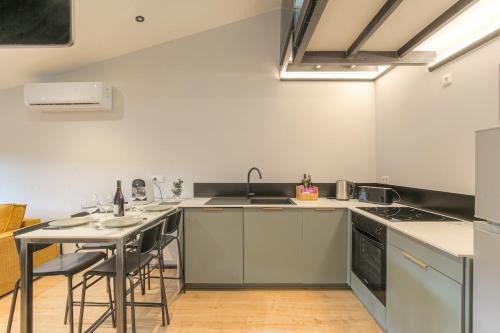 a kitchen with a sink and a table with chairs at Le Chaleureux - Travelhome in Villefranche-sur-Saône