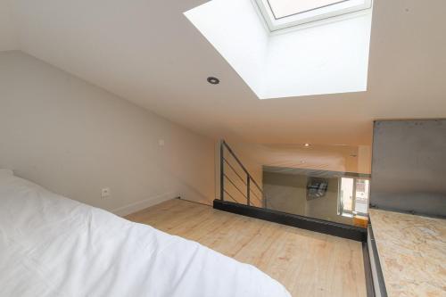 an attic room with a skylight and a wooden floor at Le Chaleureux - Travelhome in Villefranche-sur-Saône
