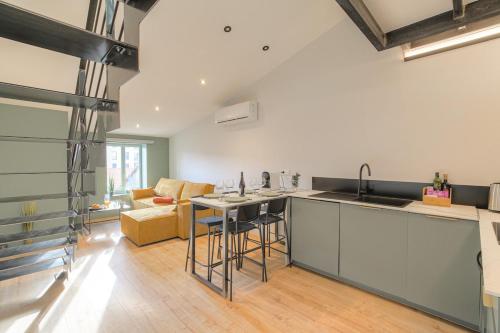 an open kitchen and living room in a loft at Le Chaleureux - Travelhome in Villefranche-sur-Saône