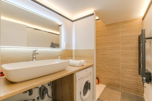 a bathroom with a sink and a washing machine at Le Chaleureux - Travelhome in Villefranche-sur-Saône