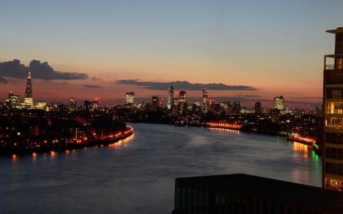 a view of a river with a city at night at Canary Riverside Plaza Hotel in London
