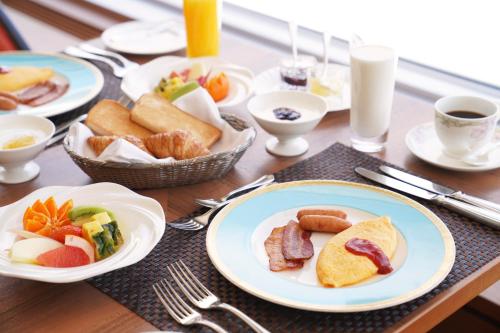 a table with plates of breakfast food on it at Shizukuishi Prince Hotel in Shizukuishi