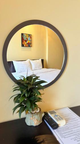 a mirror on a desk with a plant on a table at Lá Hotel in Quang Ngai