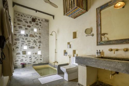 a bathroom with a tub and a sink and a toilet at Maya Luxury The Quila Udaipur in Udaipur