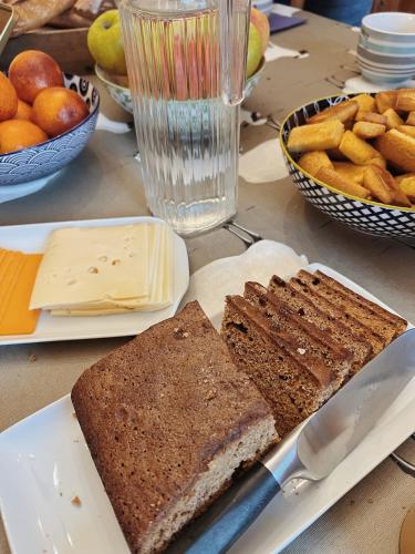 una mesa con un plato de pan y un cuchillo en CH2 - MANOIR DU MOULINIER - Campagne - Calme - Petit-déjeûner inclus - Table d'hôte sur réservation - Parking gratuit, en La Limouzinière
